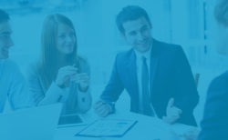 monocolor blue photo of a man and woman in business suits presenting at a conference table